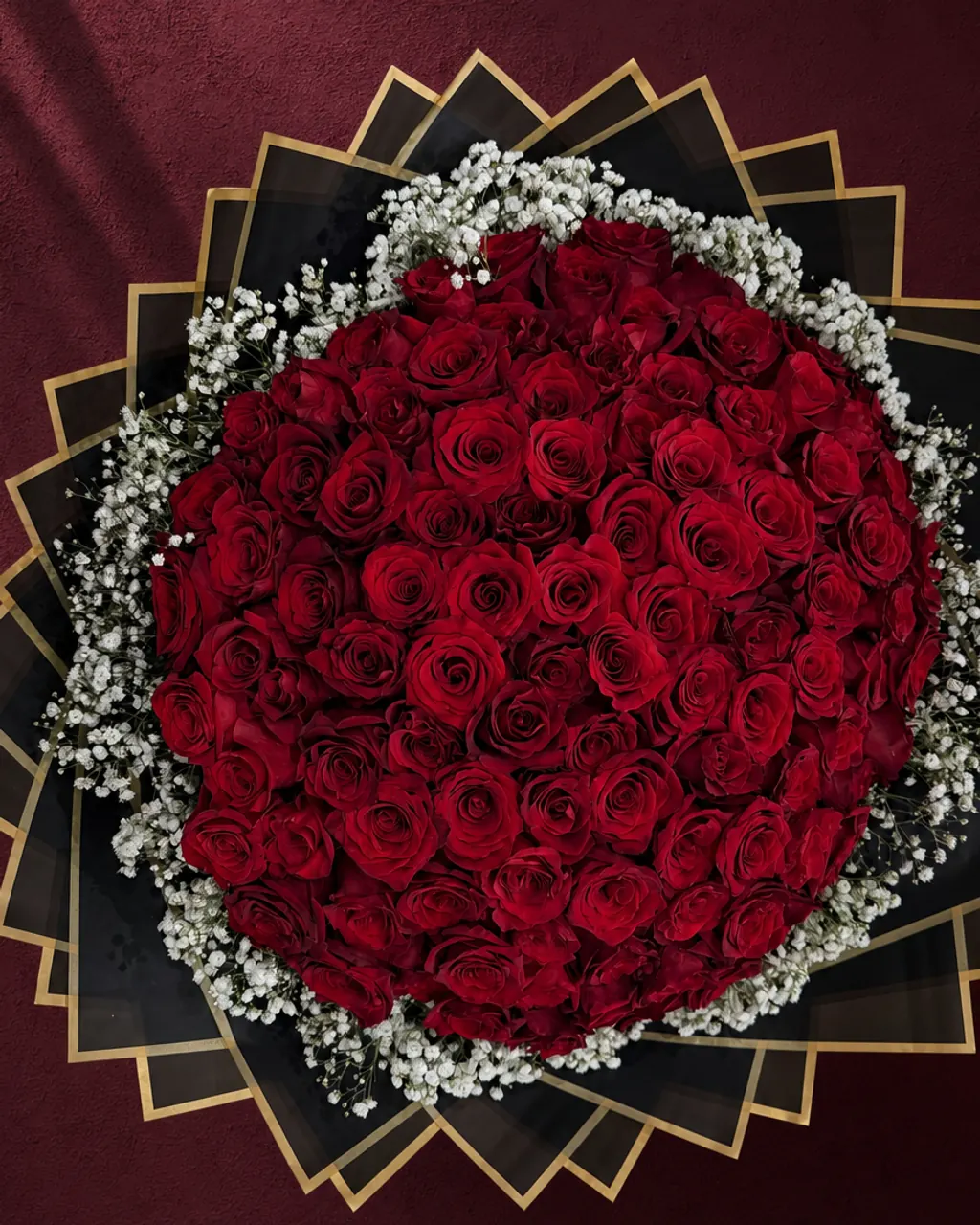 Gala Night bouquet: one hundred red roses ringed with baby's breath in black and gold wrap