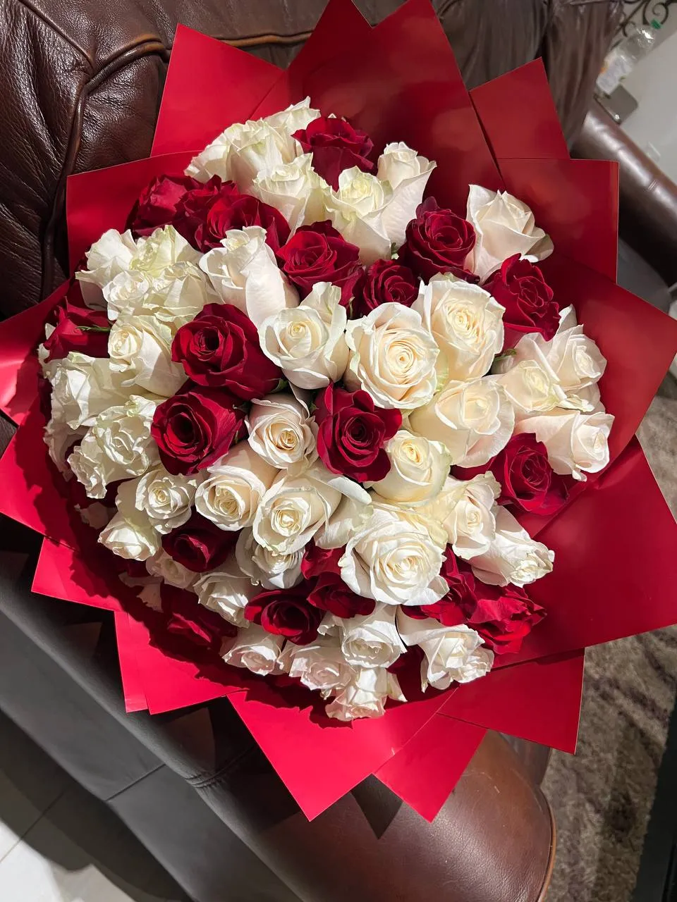 Large bouquet of red and white roses wrapped in red paper